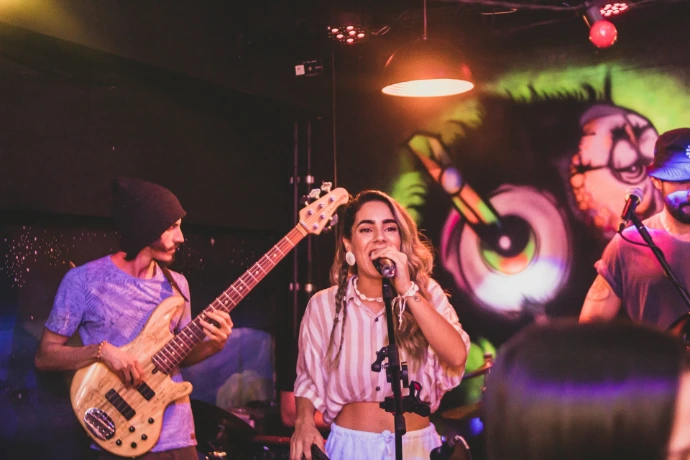 a woman singing into a microphone while holding a guitar